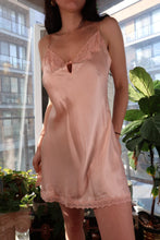 Load image into Gallery viewer, Vintage 2000s Victoria’s Secret peach silk slip dress with lace trim, styled by Elektra Vintage, hanging on a wooden hanger.