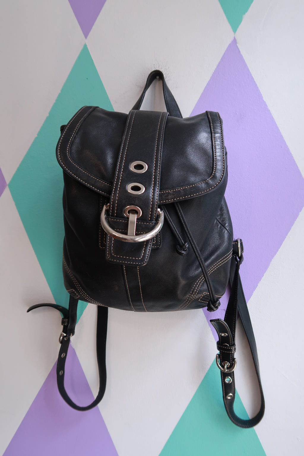 Vintage Coach Soho black leather mini backpack with drawstring closure, ideal for stylish Y2K-inspired bag and purse looks.