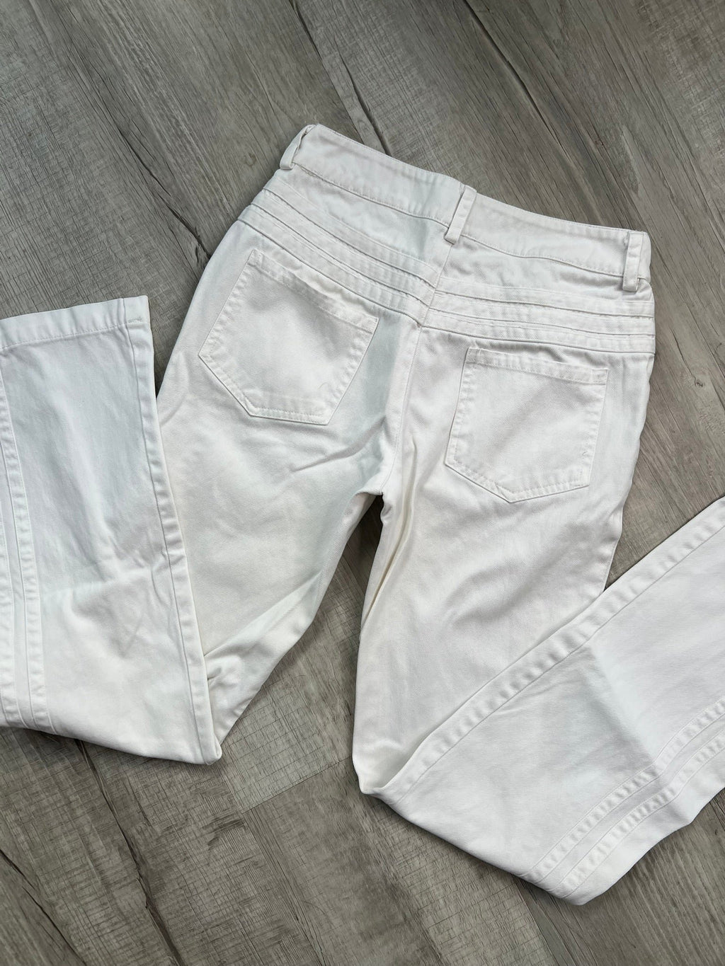 2000s vintage white denim low rise jeans for women by Elektra Vintage, showcasing a classic, casual style.