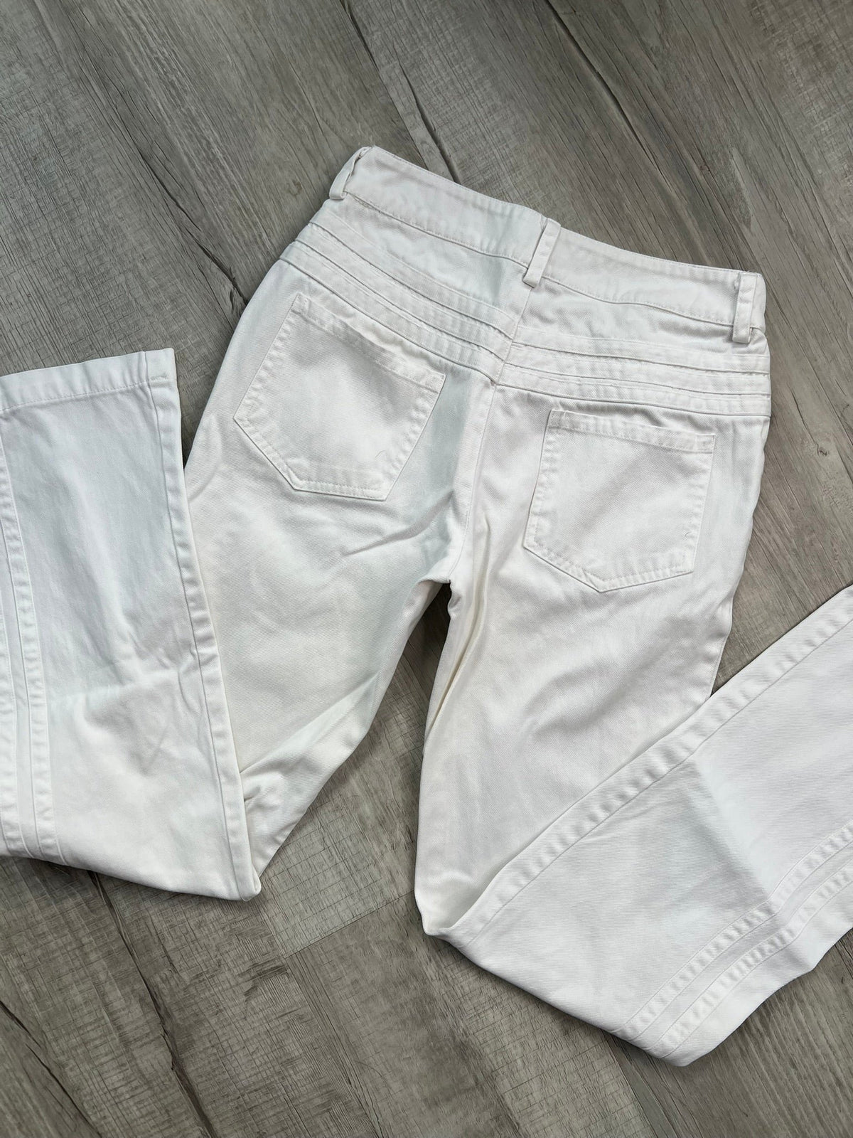 2000s vintage white denim low rise jeans for women by Elektra Vintage, showcasing a classic, casual style.
