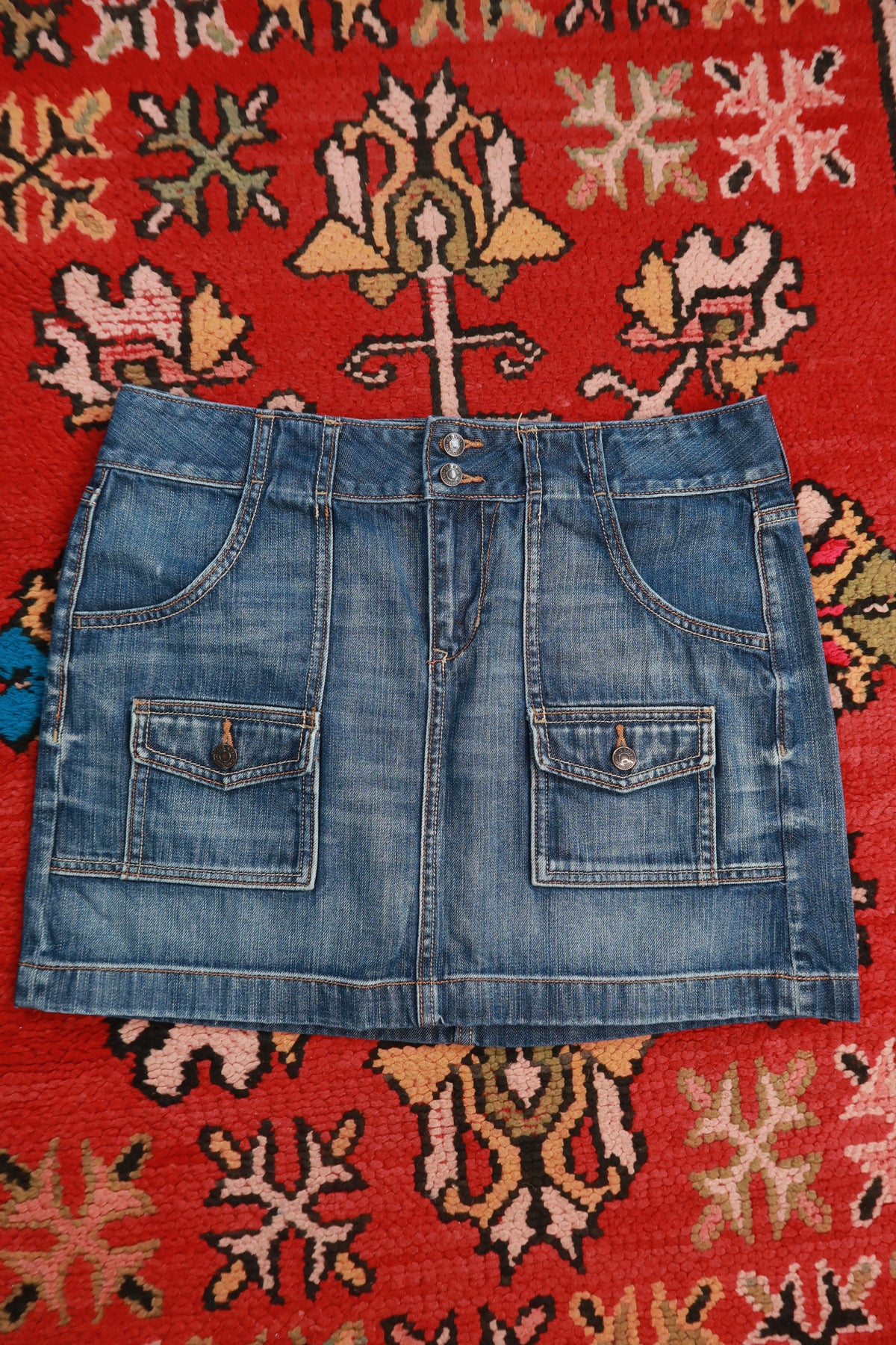 Vintage 2000s Old Navy denim mini skirt with cargo pockets, styled by Elektra Vintage, featuring a classic distressed look.