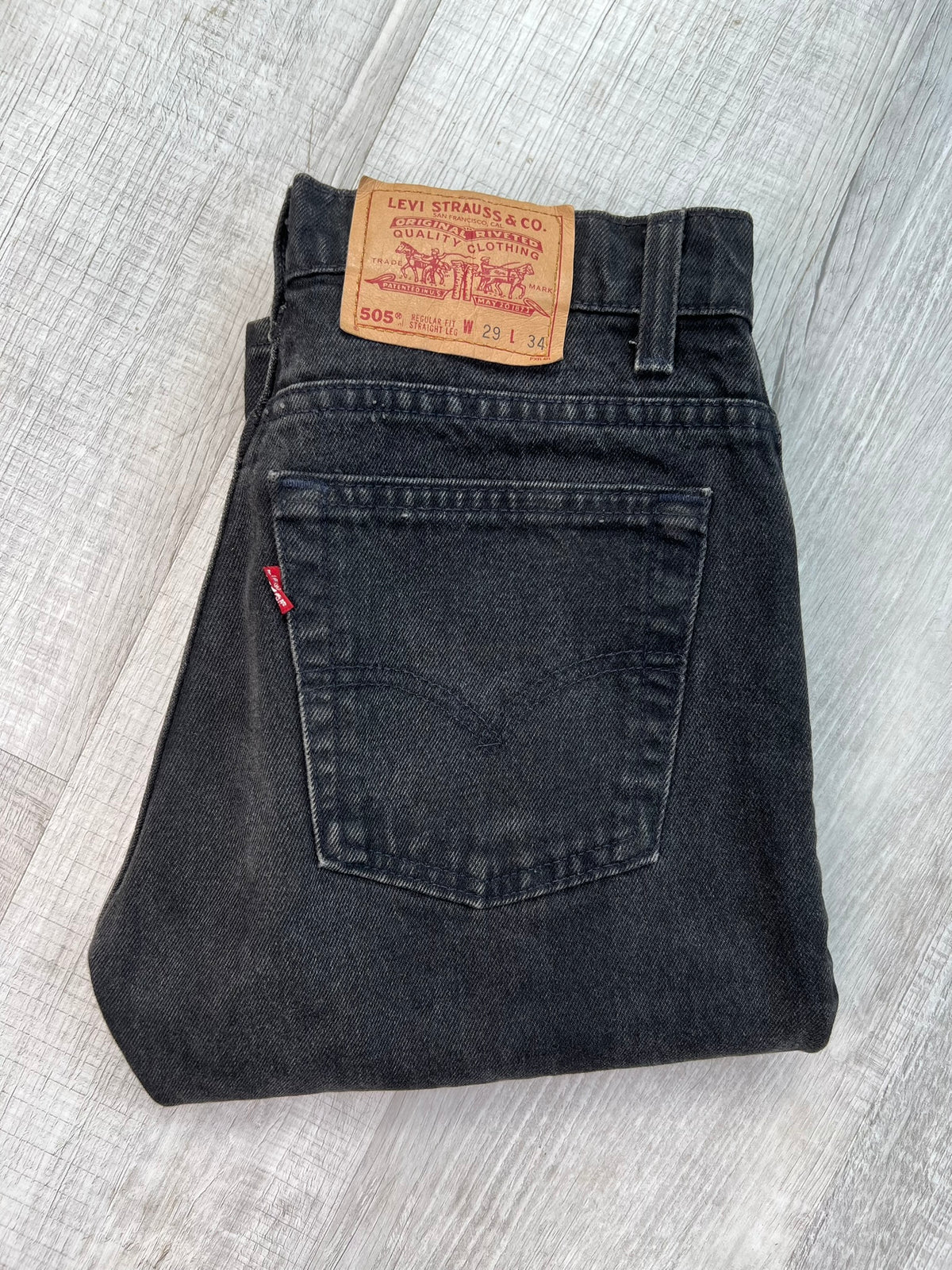 Vintage black Levi's 505 jeans from Elektra Vintage, displayed flat with detailed stitching and classic fit.