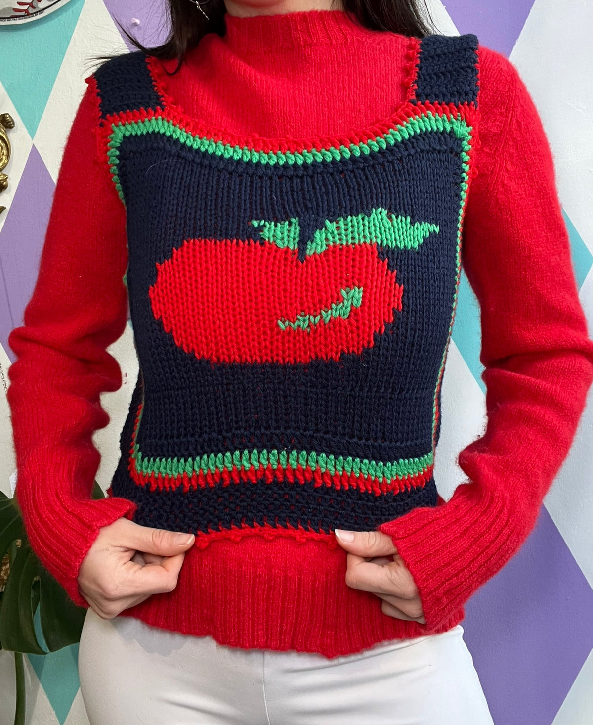 Vintage Apple sweater vest on a women's top, featuring retro-inspired design and Elektra Vintage branding.