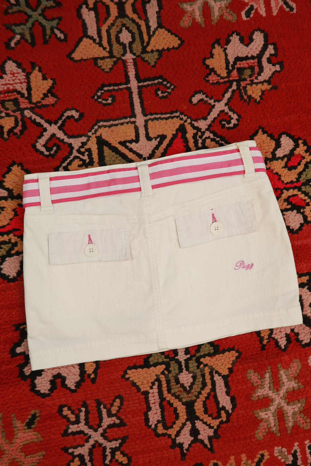 Vintage white denim mini skirt with pink stripe belt, by Elektra Vintage, featuring Y2K style and classic denim texture.