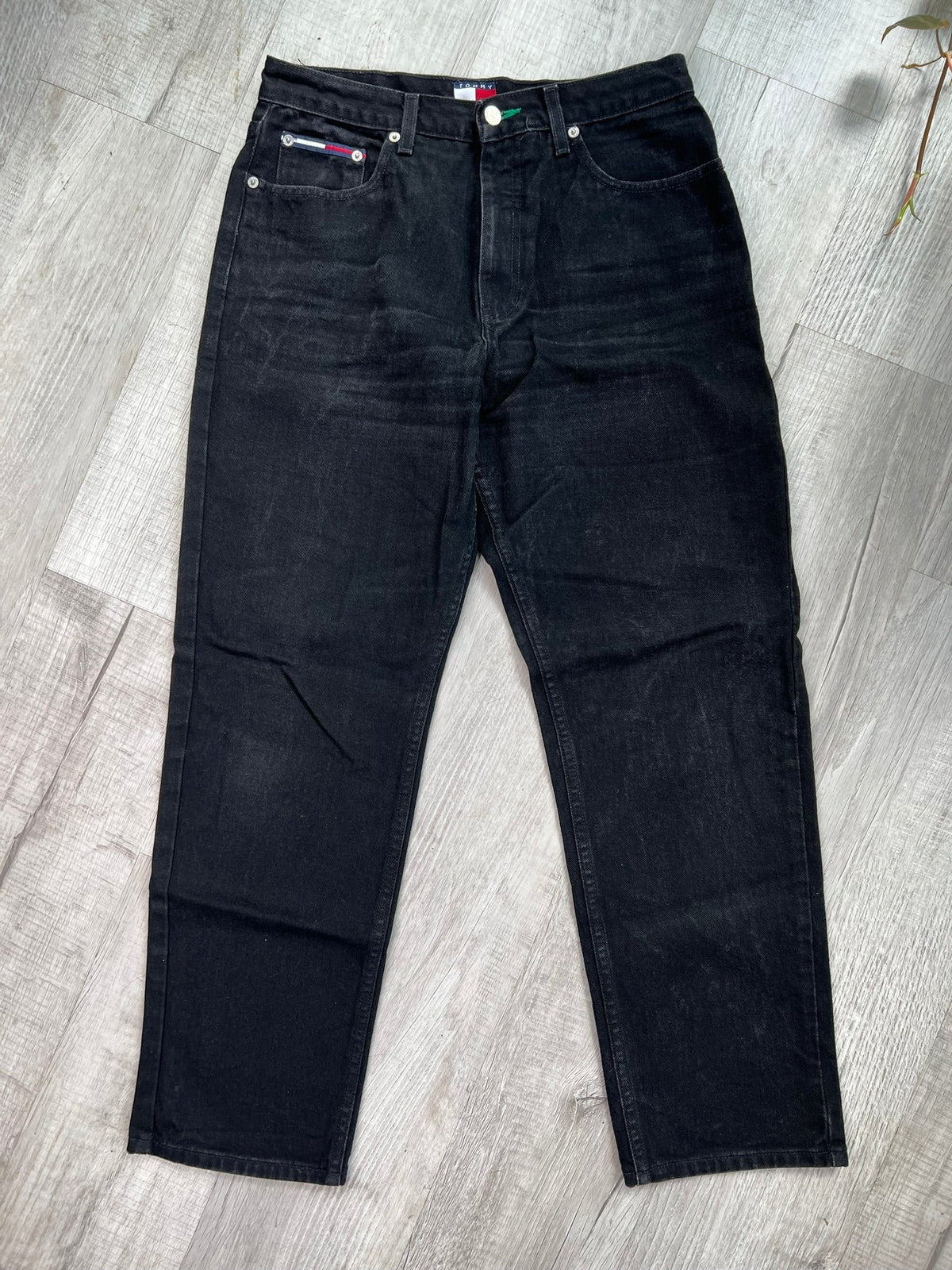 Men's relaxed fit black wash Tommy Hilfiger jeans from Elektra Vintage, showing the casual style and denim texture.