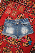 Distressed denim shorts for women with embroidered waistband by Elektra Vintage, showing frayed edges and colorful embroidery detail.