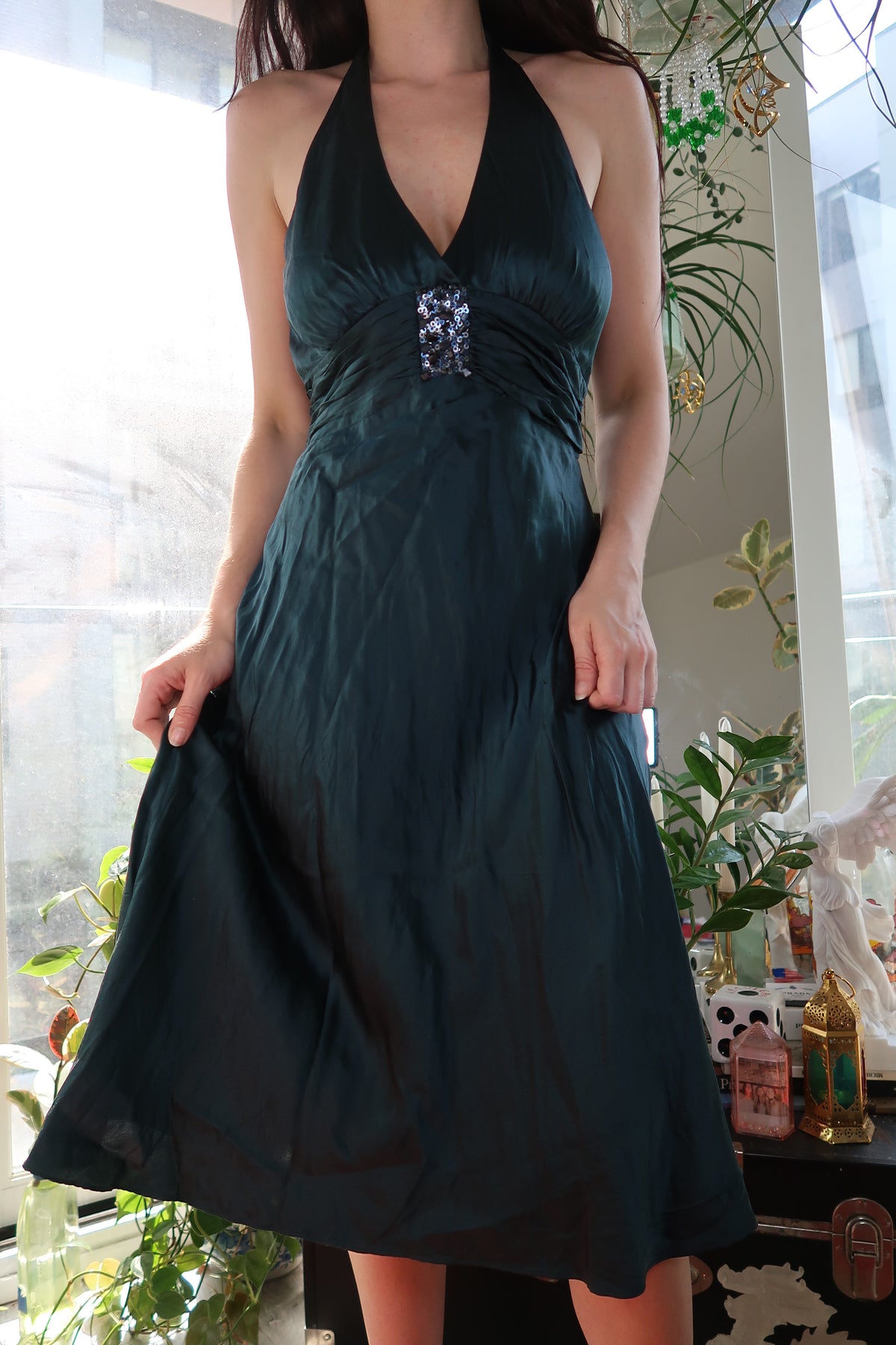 Vintage 2000s dark teal silk dress with emerald green halter neckline by Elektra Vintage displayed on a hanger.