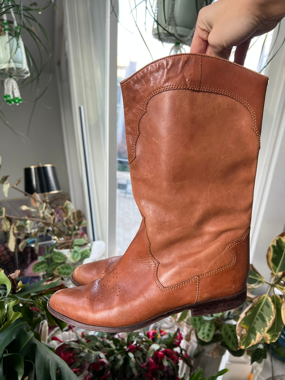 Vintage tan western cowboy boots by Elektra Vintage with pointed toes and decorative stitching on leather shaft.