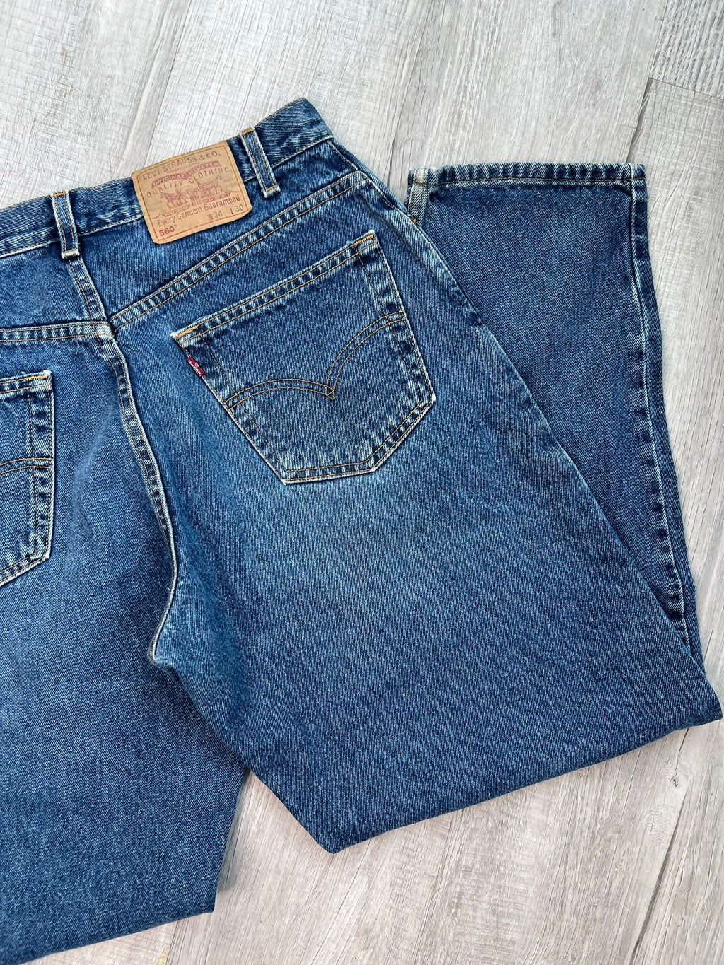 Elektra Vintage Levi's 560 loose fit tapered leg blue wash jeans displayed on a hanger with a casual fit and classic denim look.