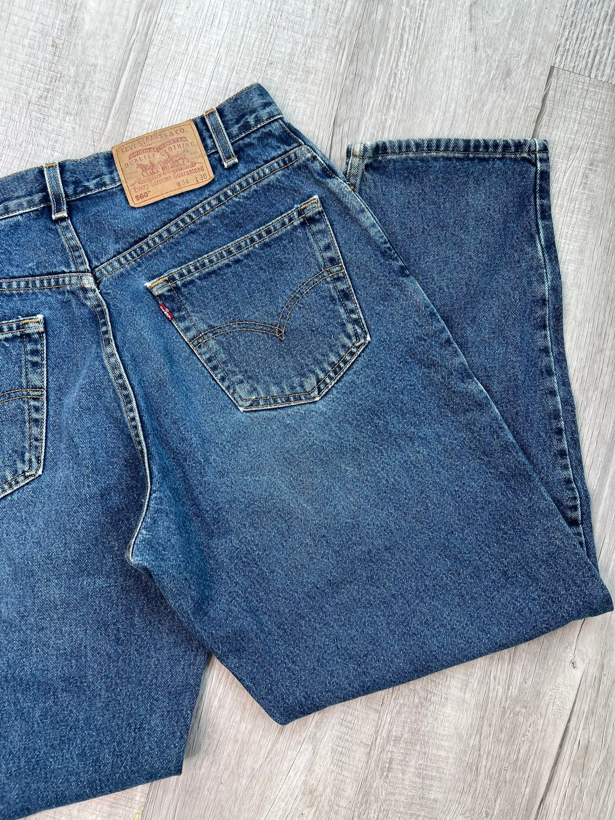 Elektra Vintage Levi's 560 loose fit tapered leg blue wash jeans displayed on a hanger with a casual fit and classic denim look.