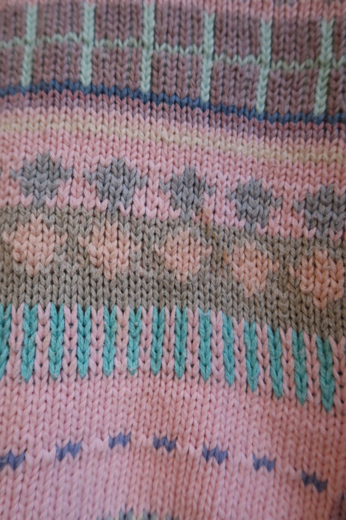 Pink Fair Isle sweater by Chompas Del Peru in a cozy knit, featuring traditional pattern, worn by a person with blonde hair.