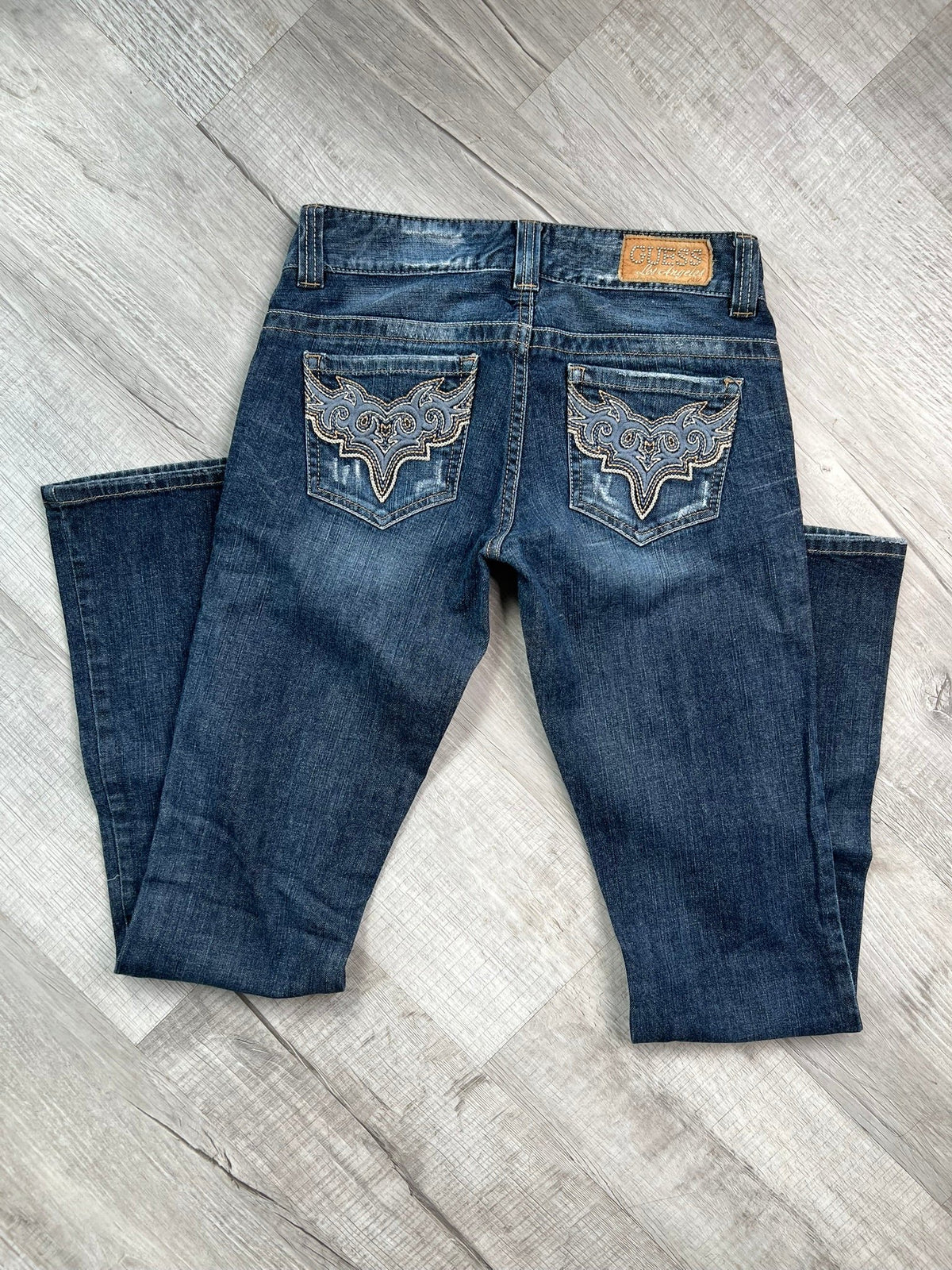 Women's low rise denim Guess jeans from the 2000s vintage collection, styled with classic blue wash and subtle fading.