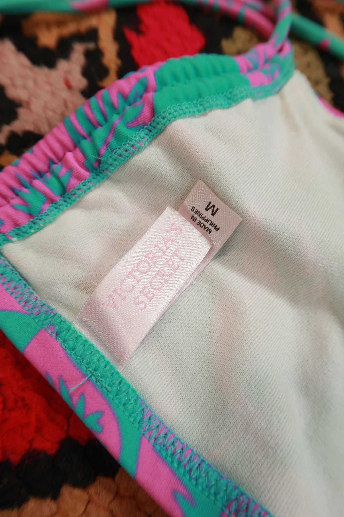 Vintage 2000s Victoria’s Secret tropical floral bandeau bikini top in vibrant colors, displayed on a mannequin.