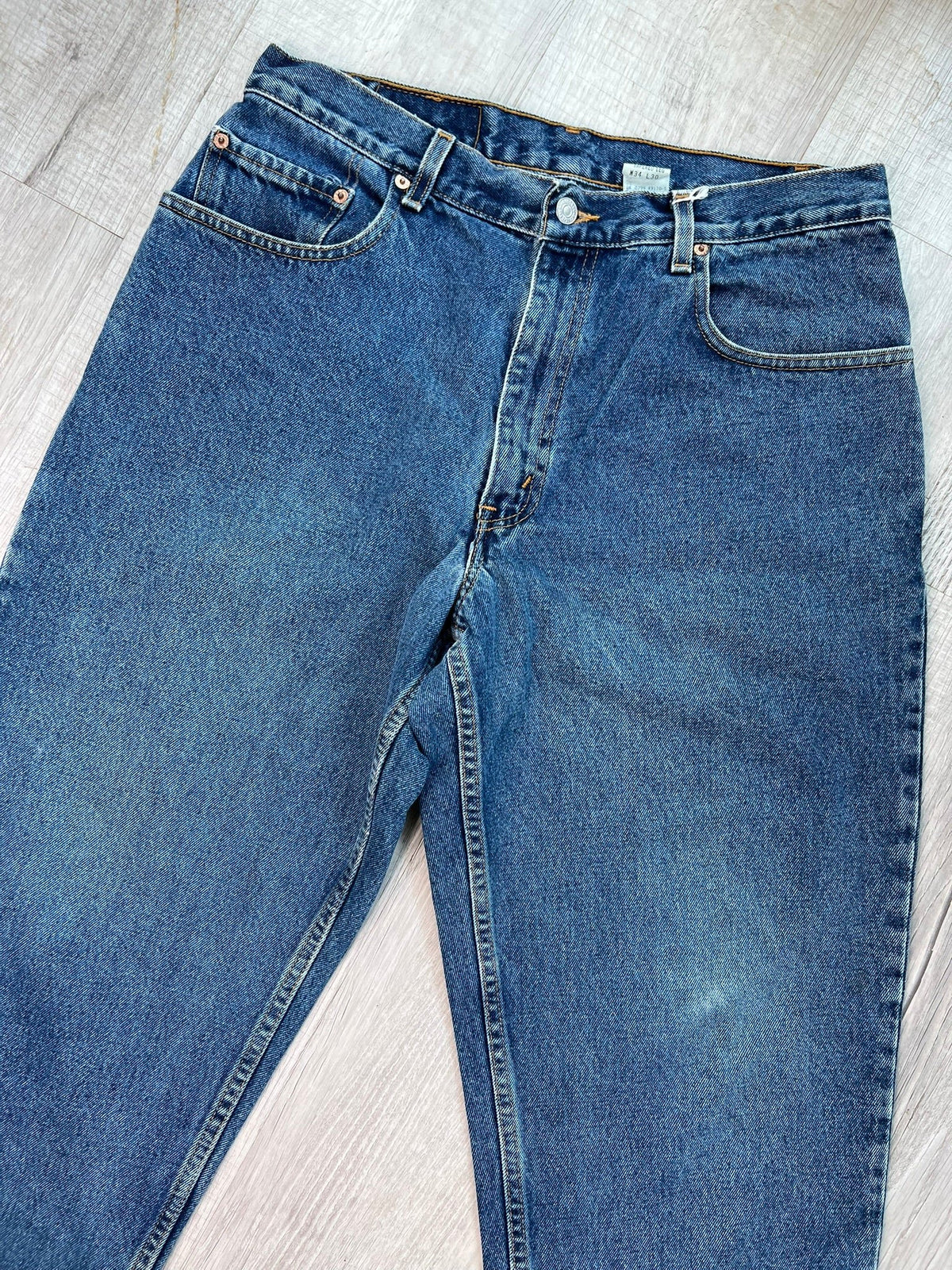 Elektra Vintage Levi's 560 loose fit tapered leg blue wash jeans displayed on a hanger.