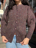 Vintage plum metallic knit cardigan by Elektra Vintage, showing a close-up of the shimmering fabric and classic button details.