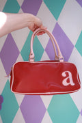 Vintage Y2K red mini bowling bag with pink trim from Elektra Vintage, featuring a compact purse design and stylish retro details.