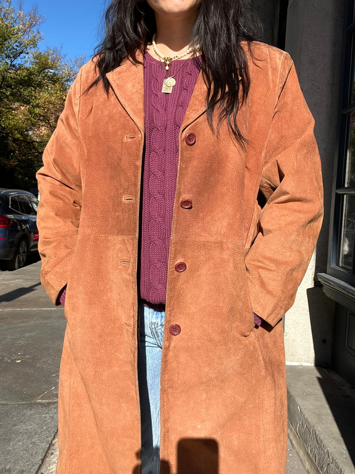 Vintage suede coat by Elektra Vintage, showcasing a classic brown suede exterior with a tailored collar and button details.