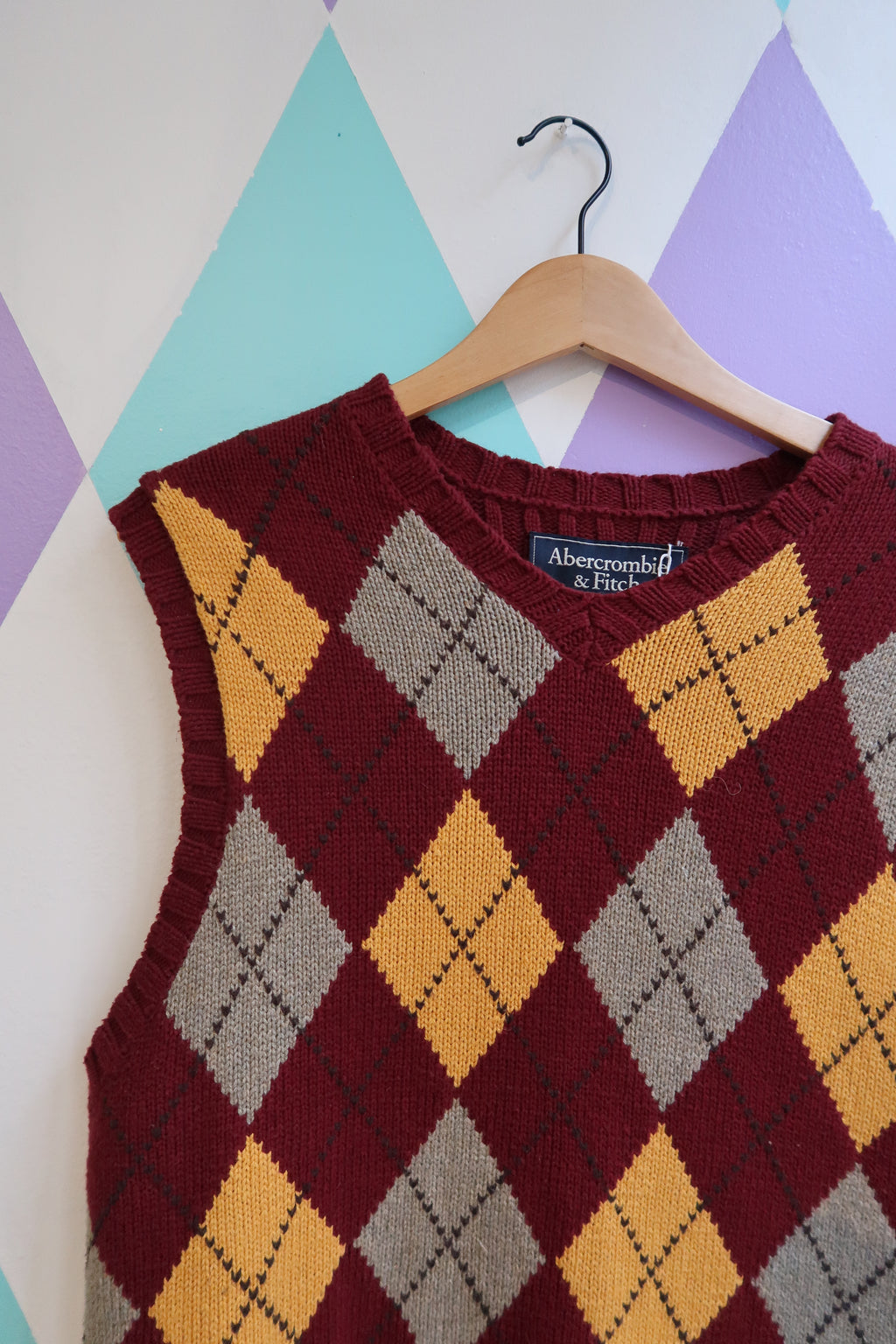 Red and yellow argyle sweater vest by Abecrombie and Fitch, featuring a classic pattern and ribbed hem, from Elektra Vintage collection.