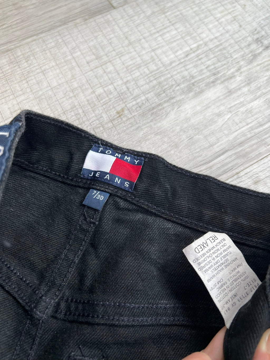 Relaxed fit black wash Tommy Hilfiger men's jeans from Elektra Vintage, showing the distressed denim style and classic fit.
