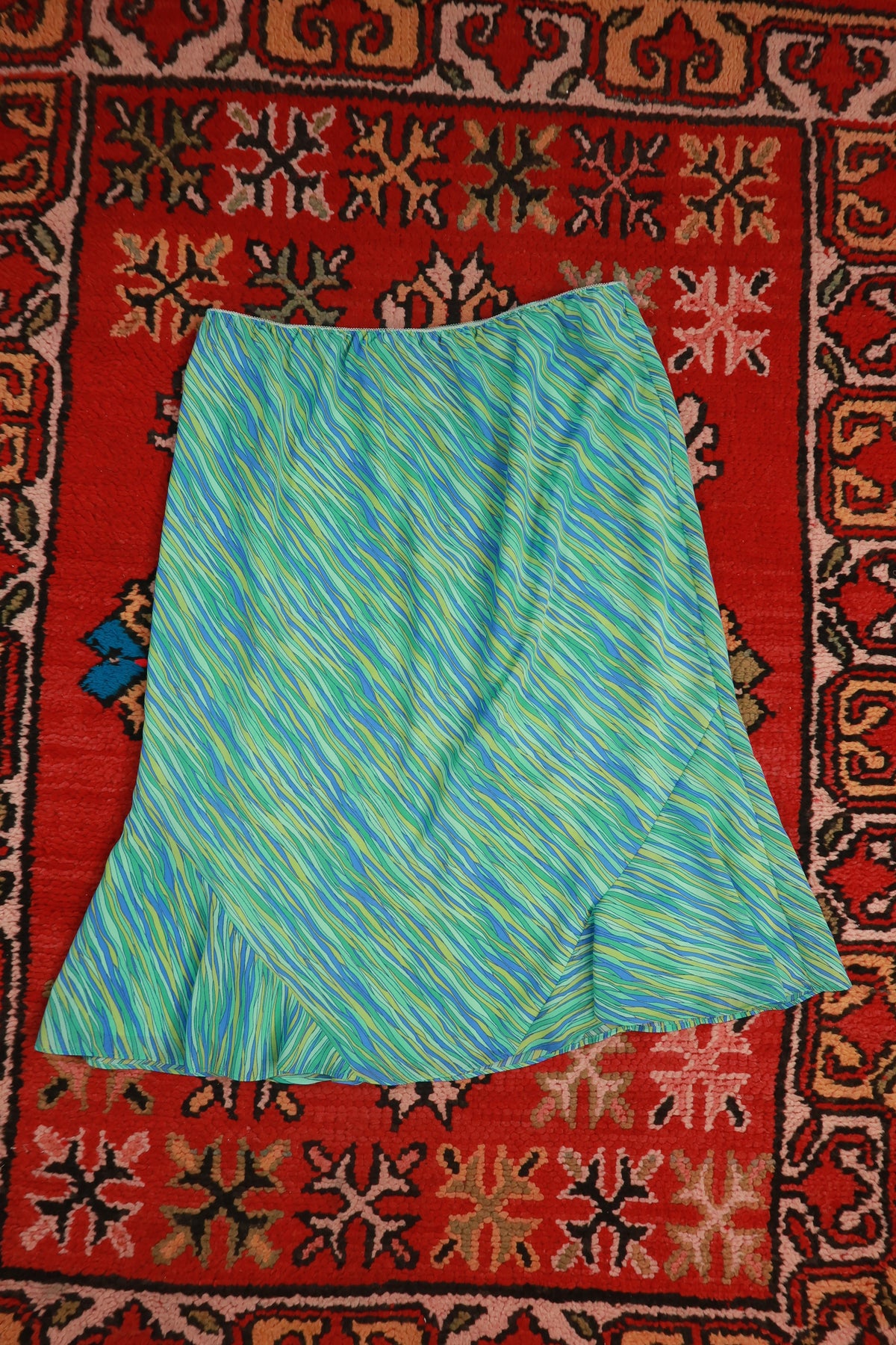 Vintage Elektra Y2K blue and green abstract print asymmetrical midi skirt displayed with flowing fabric and unique design details.