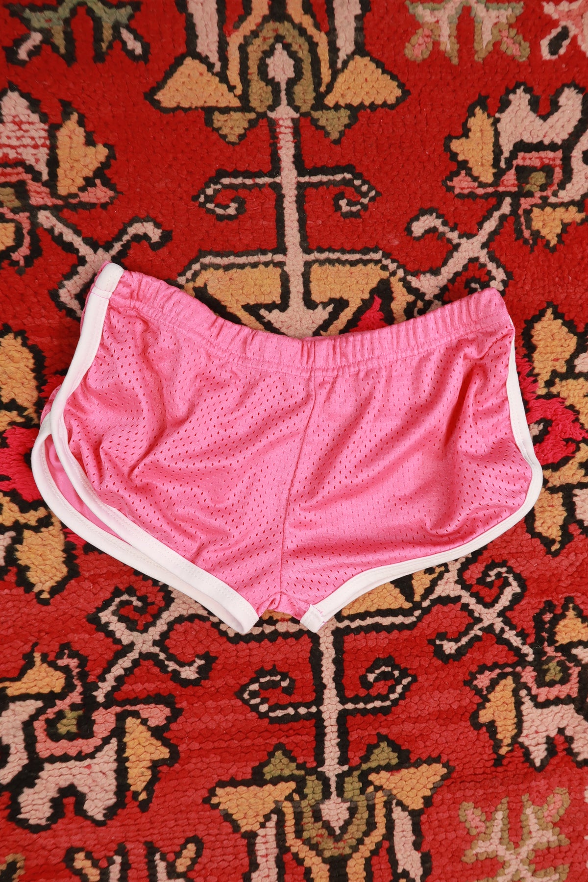 Pink vintage 2000s dice airbrush women's booty shorts by Elektra Vintage, featuring bold retro print and high-waisted fit.