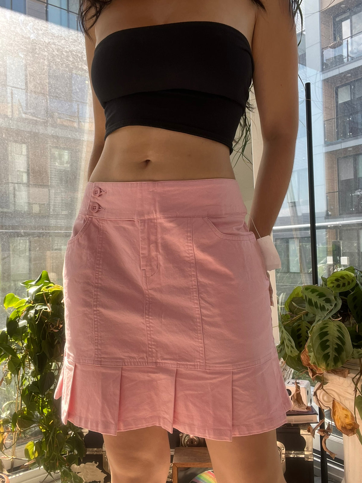 Vintage pink pleated skirt by Elektra Vintage, 2000s style, featuring soft fabric and classic A-line silhouette.