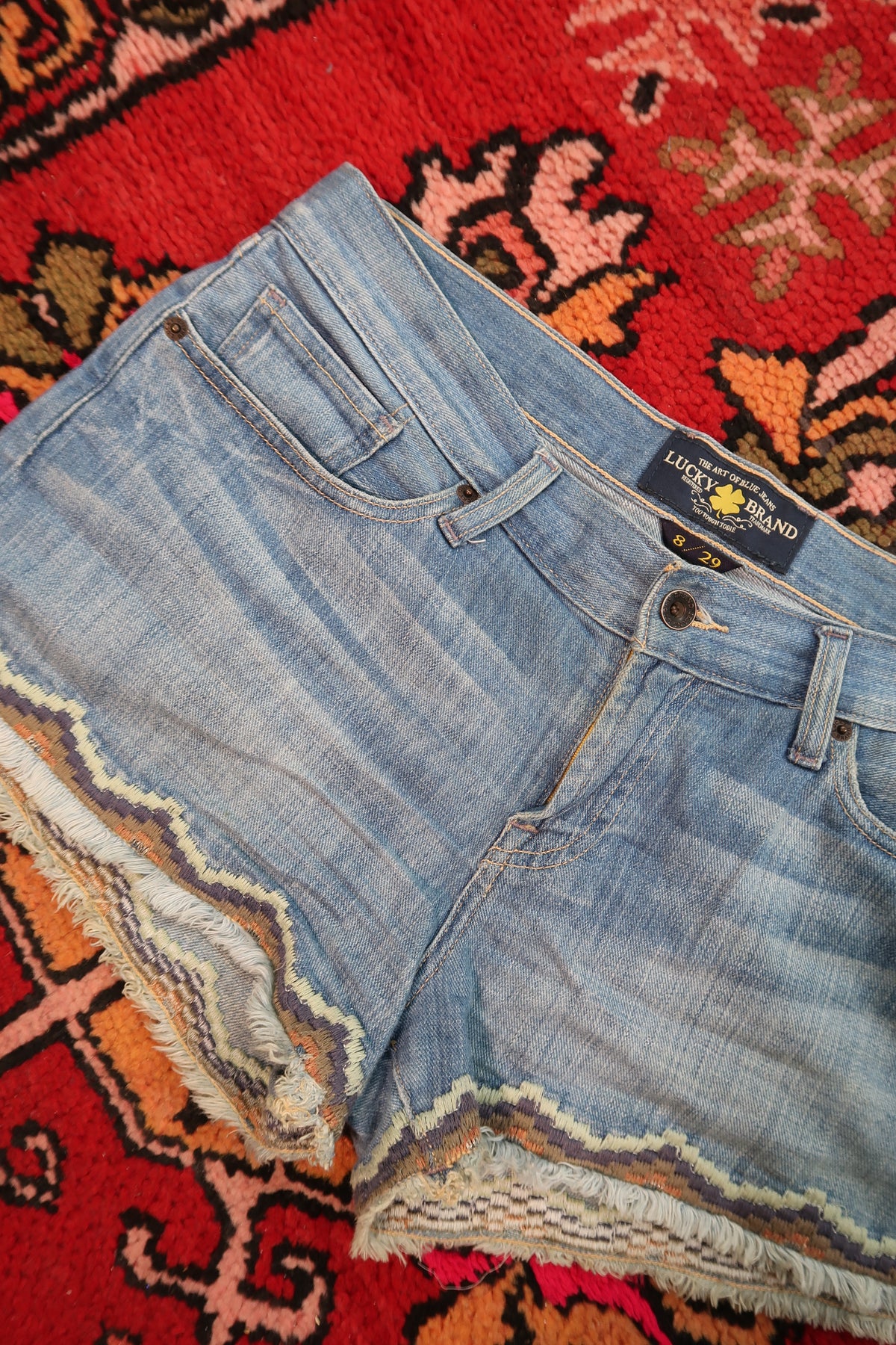 Elektra Vintage women's low-rise denim shorts with embroidered hem, featuring a vintage Lucky Brand style and distressed details.