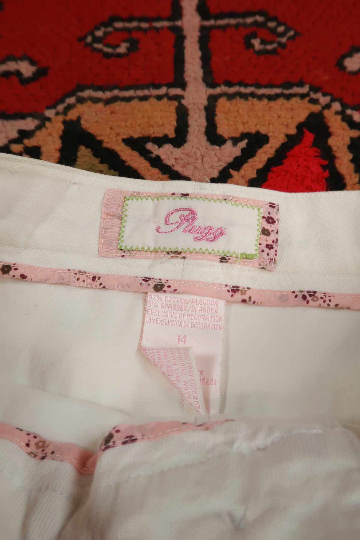 Vintage Elektra Vintage white denim mini skirt with pink stripe belt, Y2K style, featuring a fitted waist and classic denim texture.