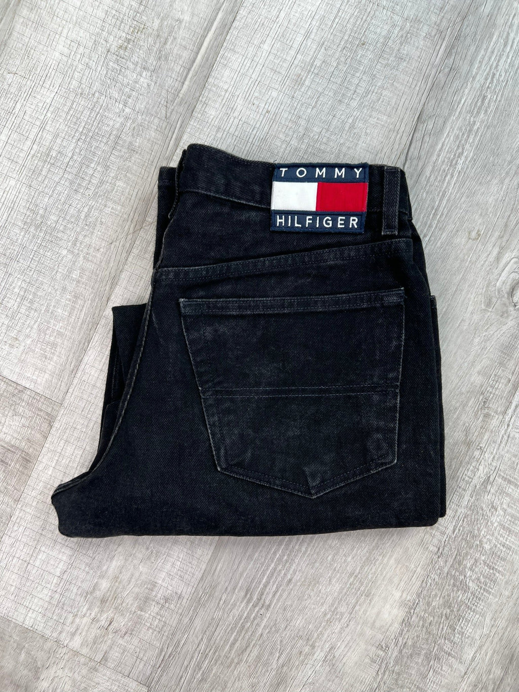 Relaxed fit black wash Tommy Hilfiger men's jeans, Elektra Vintage bottoms, showing front view with classic five-pocket design.
