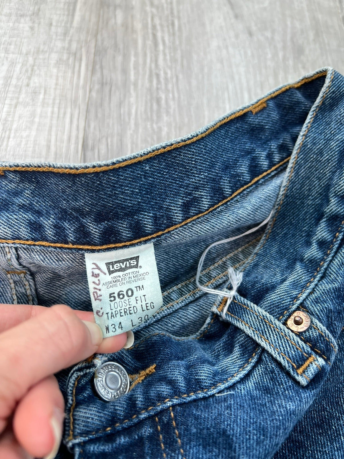 Elektra Vintage Levi's 560 loose fit tapered leg blue wash jeans displayed on a hanger.