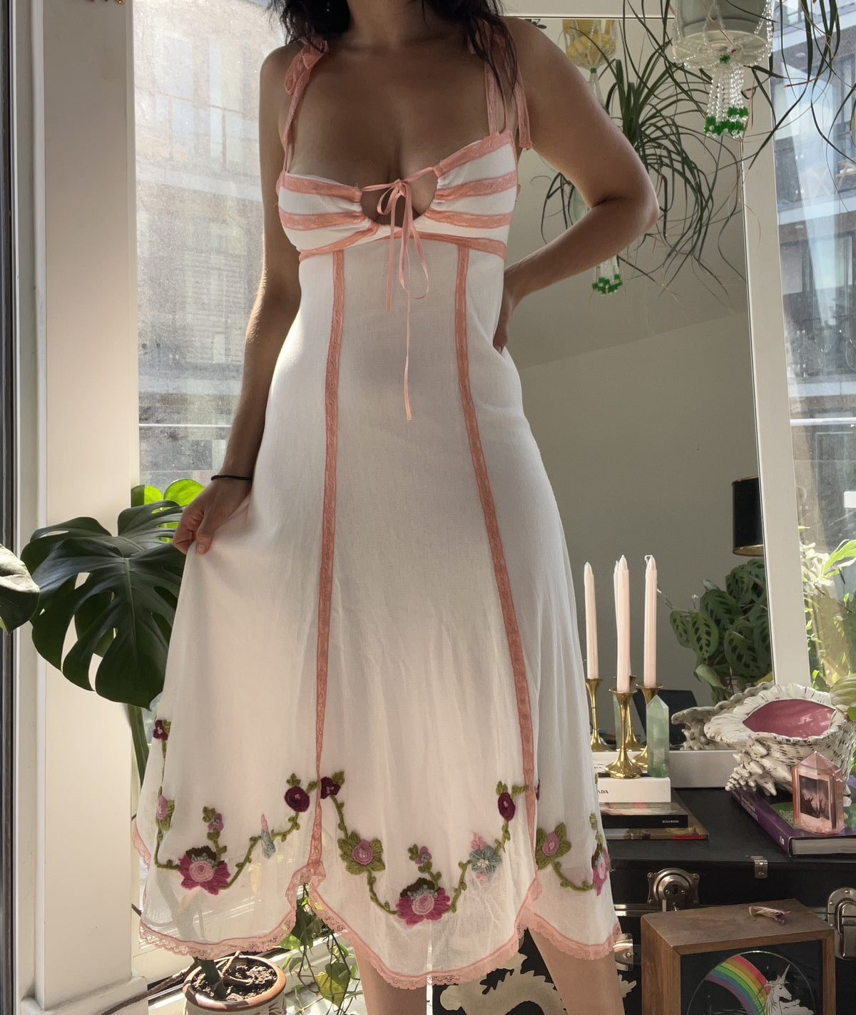 Vintage white and floral Betsey Johnson dress by Elektra Vintage, featuring a fitted bodice and flowing skirt, displayed on a hanger.