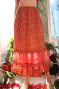 Vintage pink floral tiered midi skirt by Elektra Vintage, featuring flowing fabric and layered design.