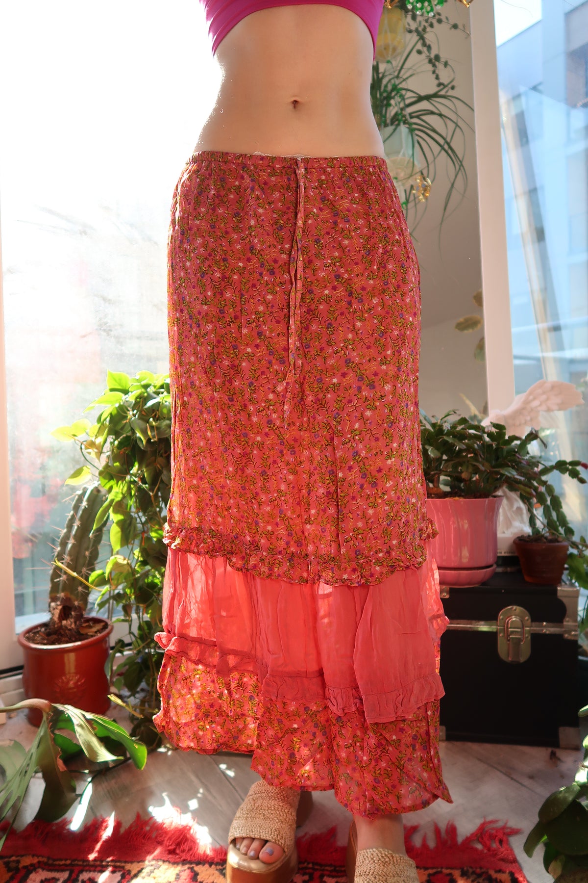 Pink floral tiered midi skirt by Elektra Vintage with layered fabric and vintage-inspired design, shown on a model.
