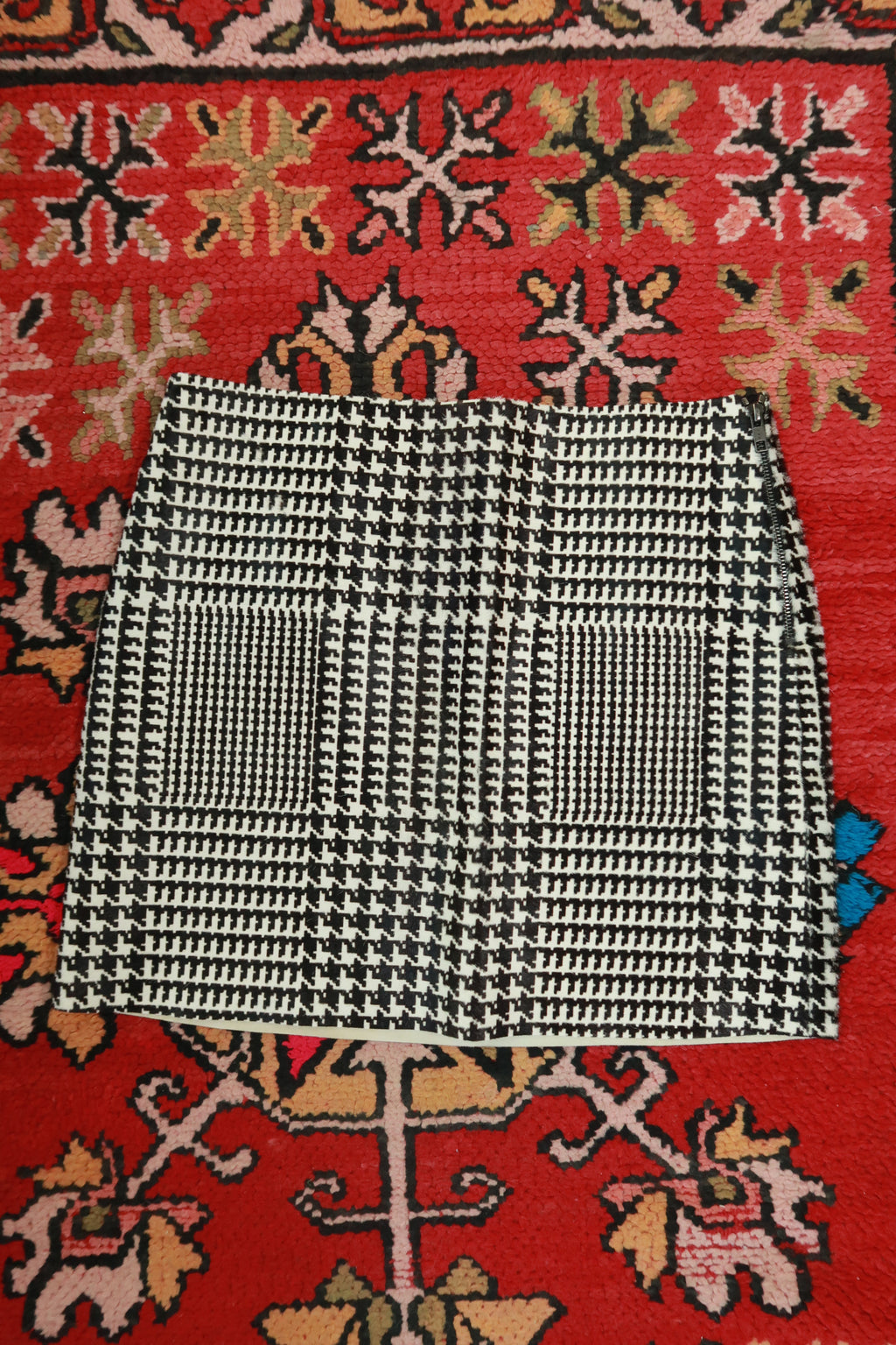 Black and white pony hair houndstooth mini skirt by Elektra Vintage, featuring a classic houndstooth pattern and fitted silhouette.