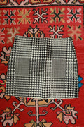 Black and white pony hair houndstooth mini skirt by Elektra Vintage, featuring a classic houndstooth pattern and fitted silhouette.