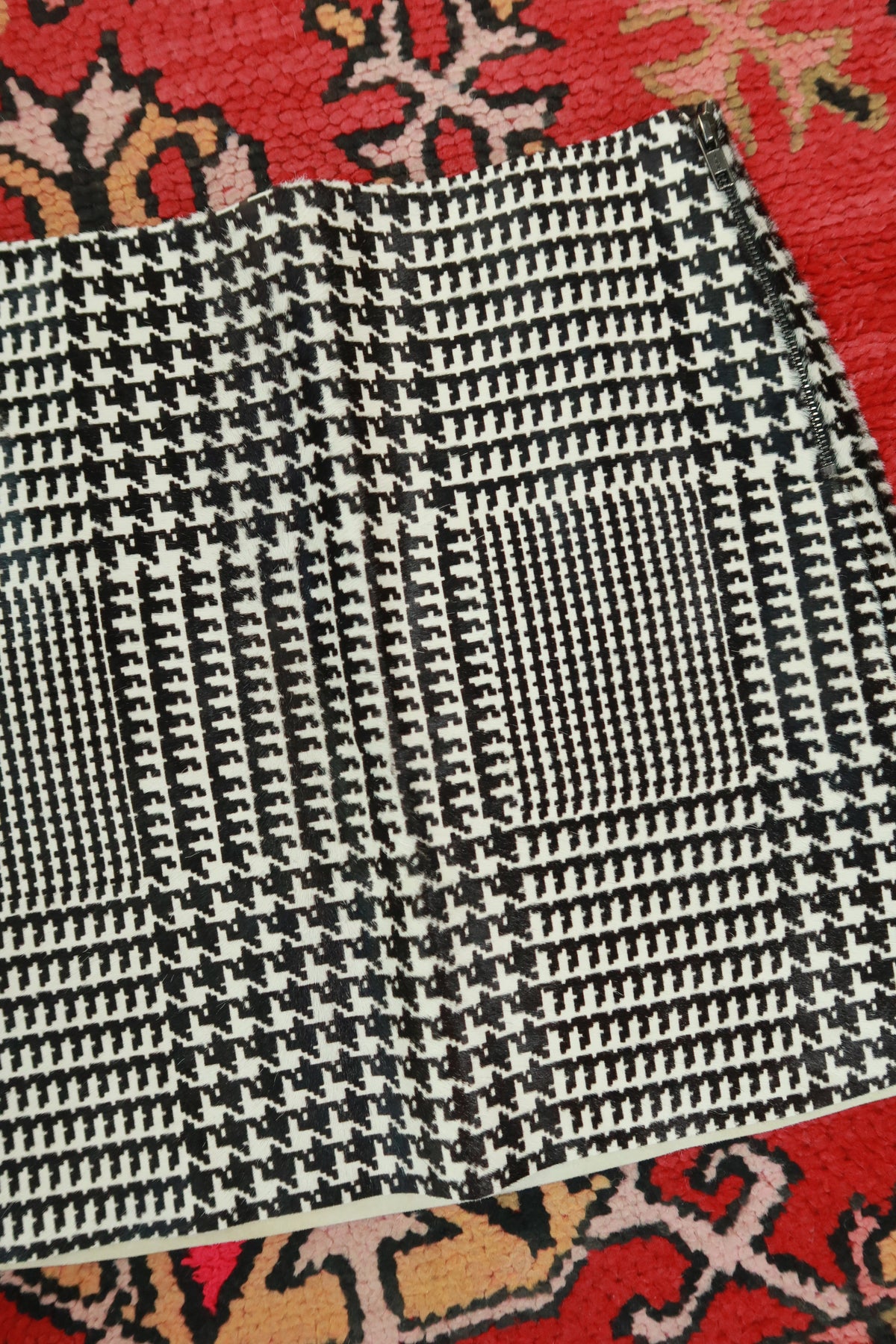 Black and white pony hair houndstooth mini skirt by Elektra Vintage, featuring a classic houndstooth pattern and fitted style.