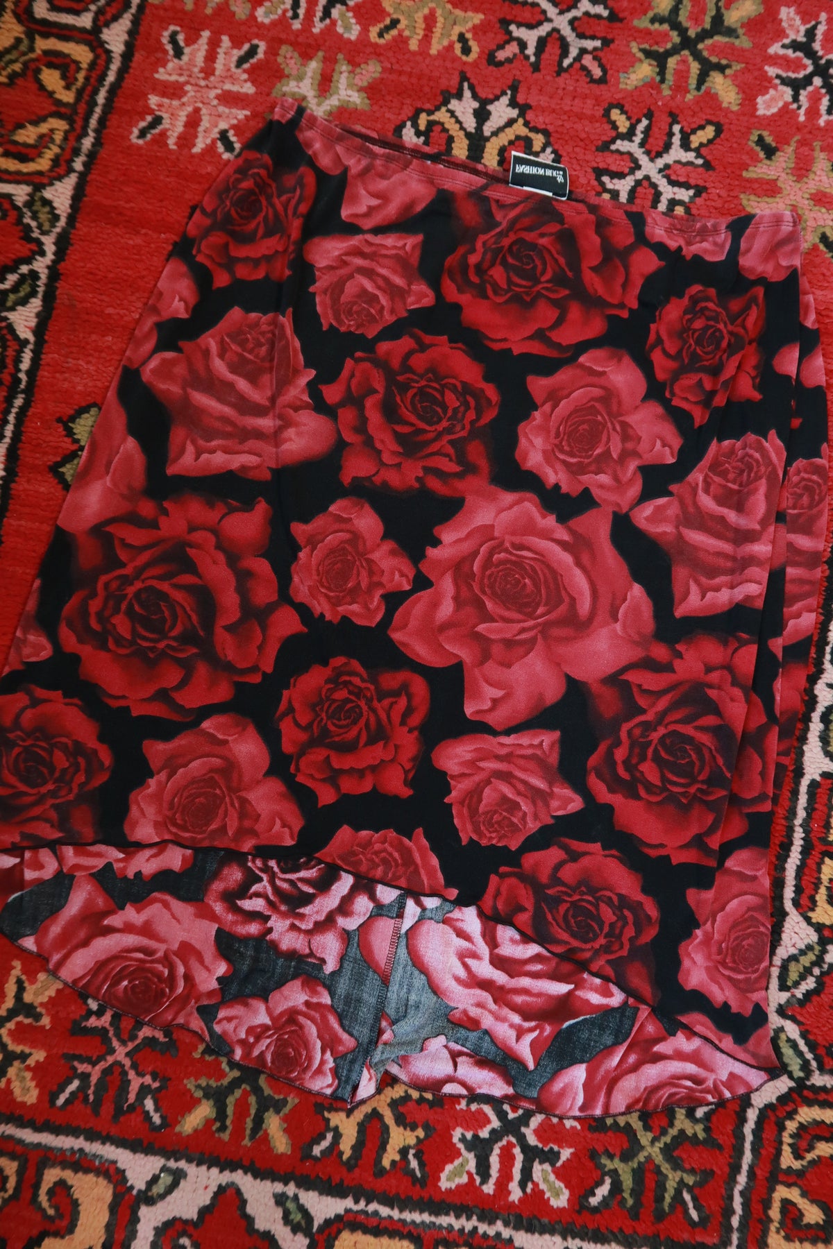 Red rose print asymmetrical skirt by Elektra Vintage, vintage 2000s style with flowing fabric and unique design details.