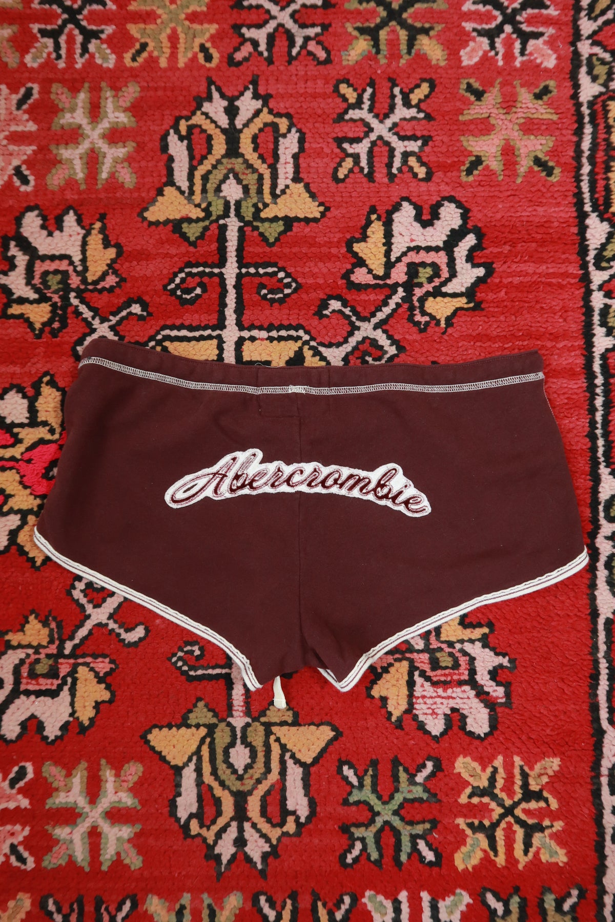 Vintage Y2K burgundy Abercrombie & Fitch dolphin shorts for women, styled with a casual, retro look, by Elektra Vintage.