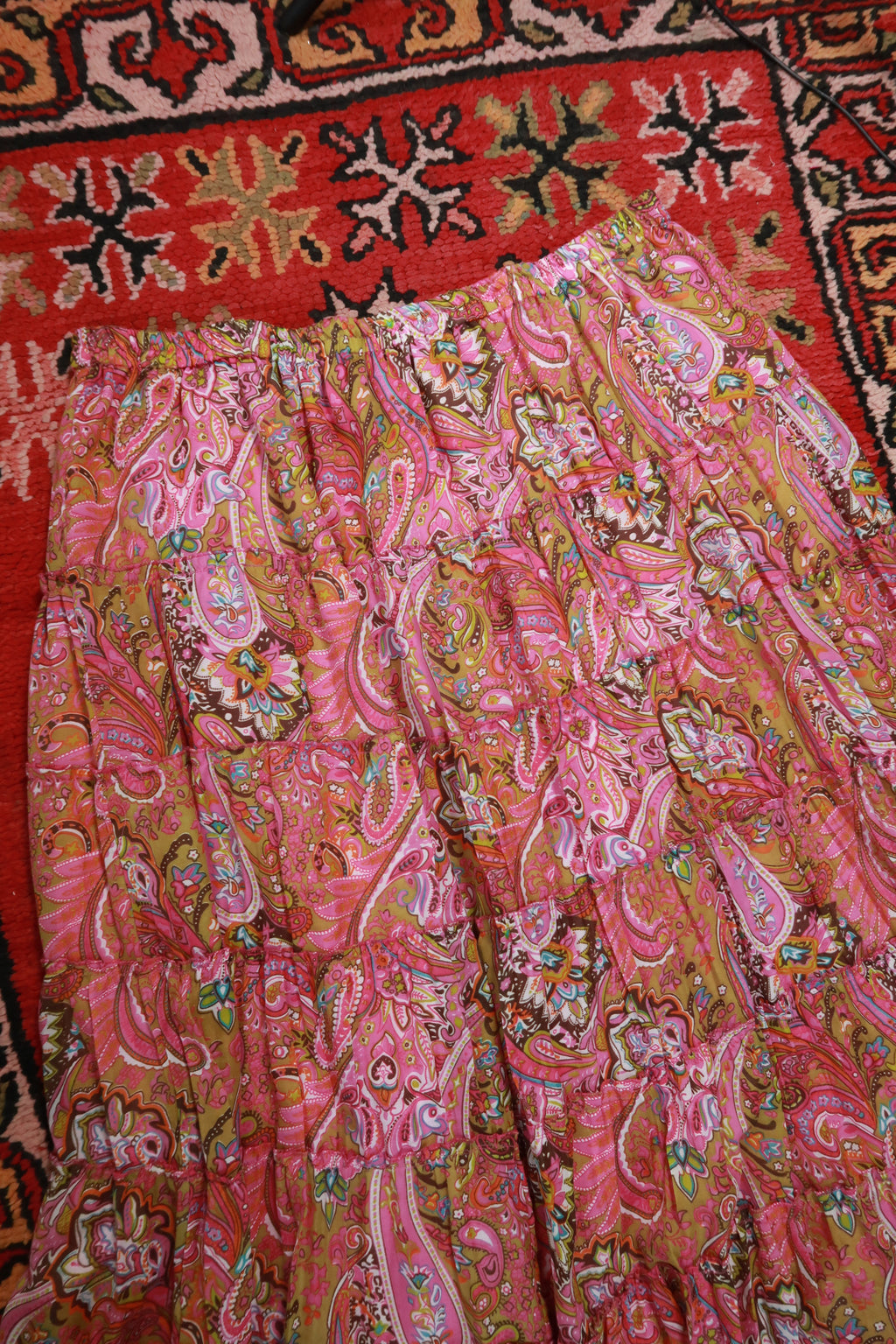 Vintage pink paisley boho midi skirt by Elektra Vintage featuring tiered design and flowing fabric.