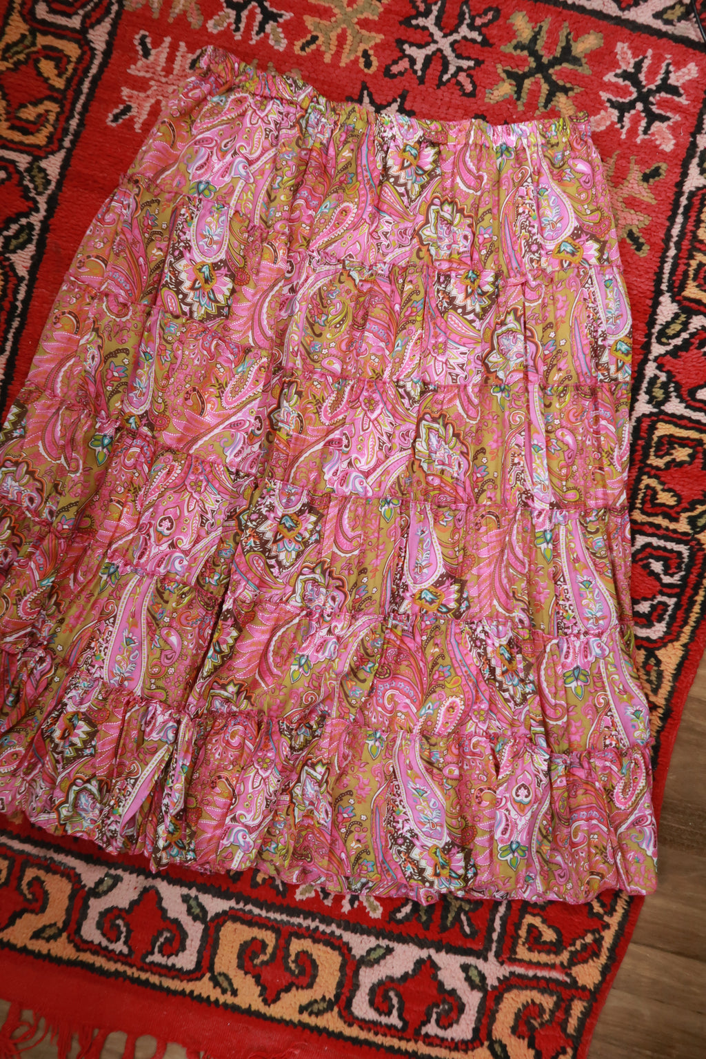 Pink paisley boho midi skirt by Elektra Vintage, tiered design with flowing fabric and vintage-inspired style.