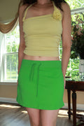 Vintage Y2K Lime Green Mini Skirt by Elektra Vintage, showing the bright mini skirt with a fitted waist and zipper detail.