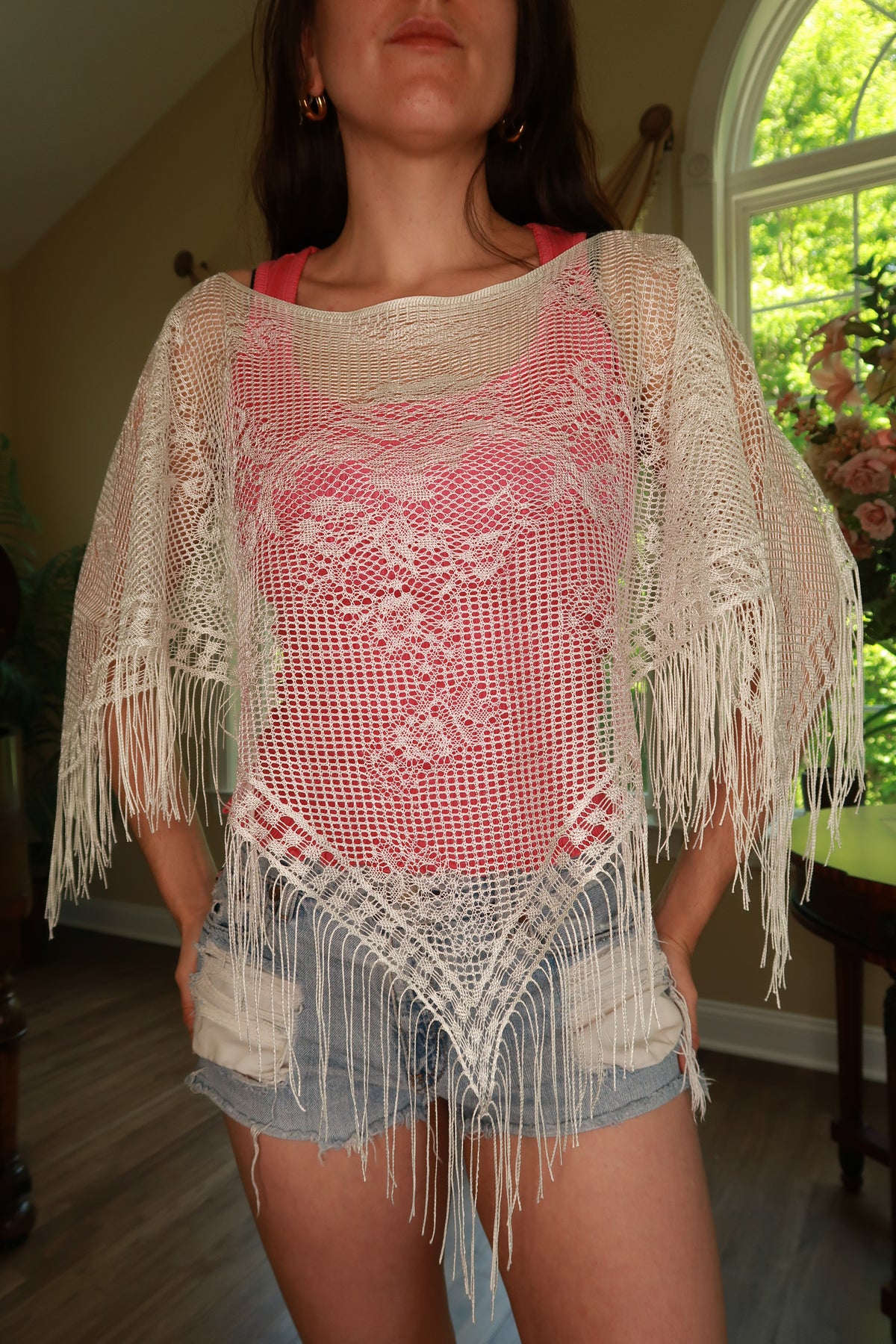 Elektra Vintage women's white crochet fringe poncho top with intricate detailing and boho style, draped on a mannequin.