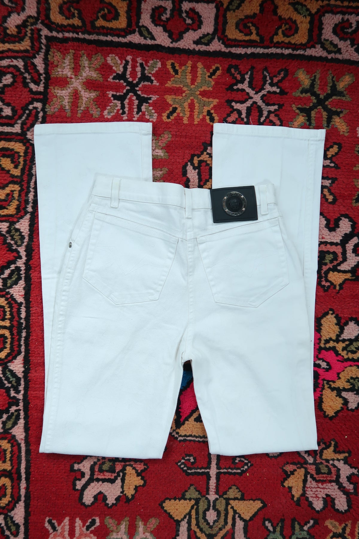 Vintage Versace Sport Slim Bootcut white jeans for women, made in Italy, by Elektra Vintage, showcased on a model.