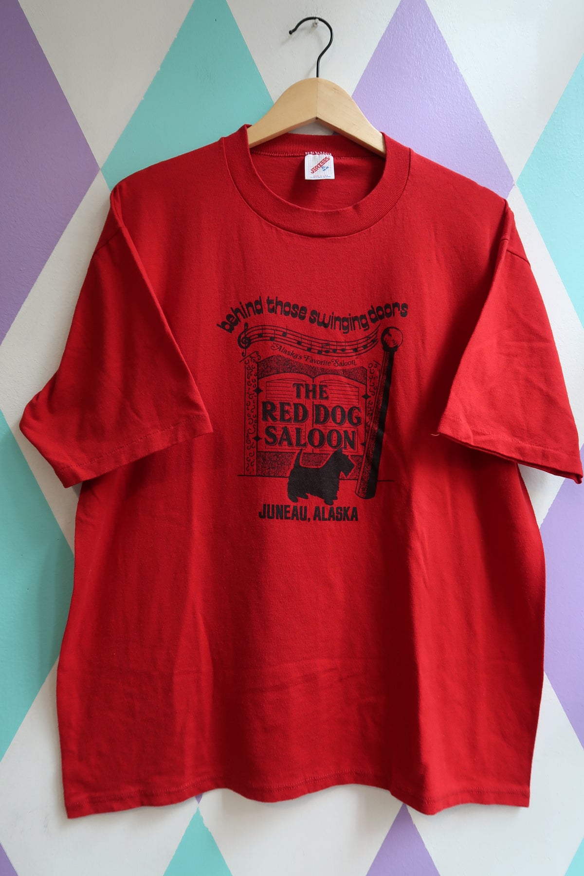 Red t-shirt with black text and graphics for the Red Dog Saloon in Juneau, Alaska