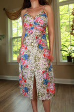 Load image into Gallery viewer, Vintage 70s Frederick's of Hollywood floral ruched midi dress displayed on a hanger, showcasing its vibrant floral pattern and elegant design.
