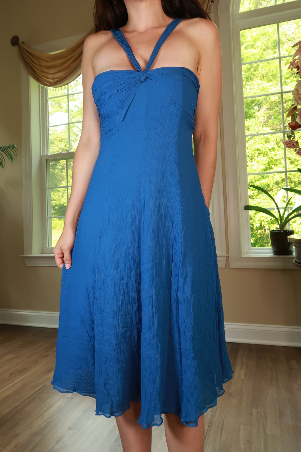 Vintage 2000s Elektra Vintage blue 100% silk halter midi dress displayed on a hanger with detailed fabric texture.