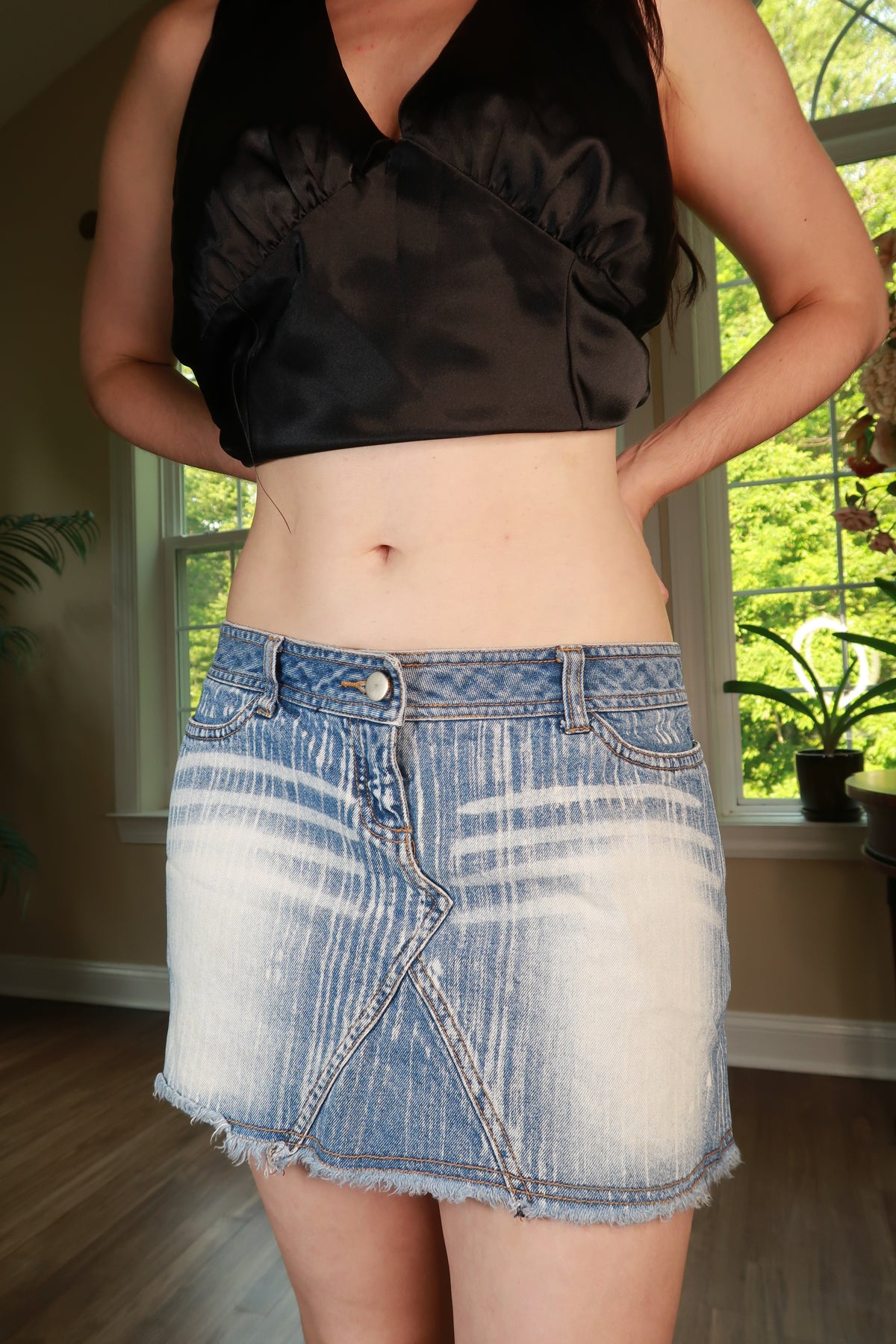 Elektra Vintage distressed denim mini skirt from the 2000s, featuring a classic fit with frayed edges and worn details.