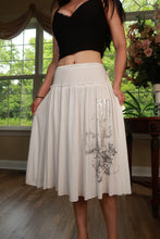 Load image into Gallery viewer, White graphic midi skirt by Elektra Vintage featuring vintage Y2K style and bold print, displayed on a hanger.
