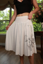 Load image into Gallery viewer, White vintage Y2K graphic midi skirt by Elektra Vintage, featuring bold print and classic mid-length design.
