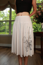 Load image into Gallery viewer, White vintage Y2K graphic midi skirt by Elektra Vintage, featuring bold print and retro style, displayed on a hanger.
